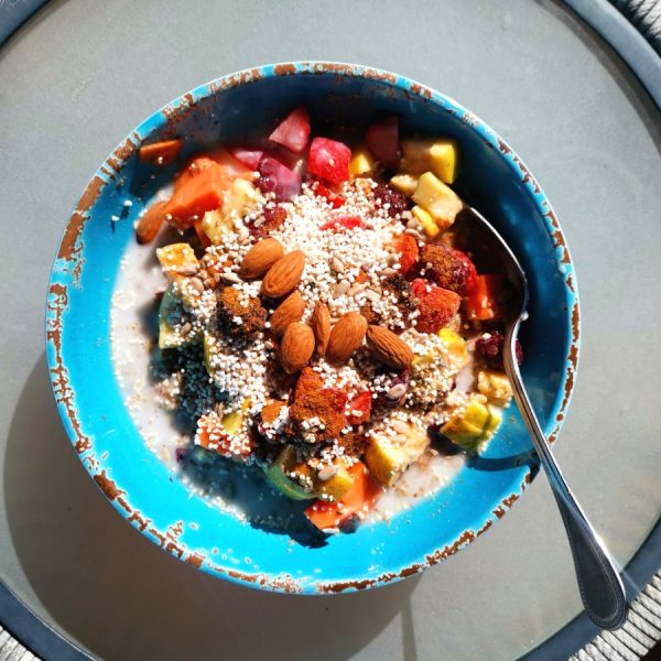 A bowl of healthy oats with nuts on a table - a good way on how to eat healthy and cheap while traveling