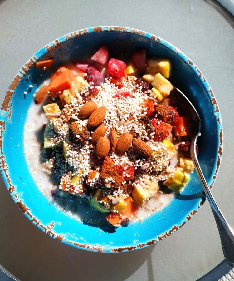 A bowl of healthy oats with nuts on a table - a good way on how to eat healthy and cheap while traveling