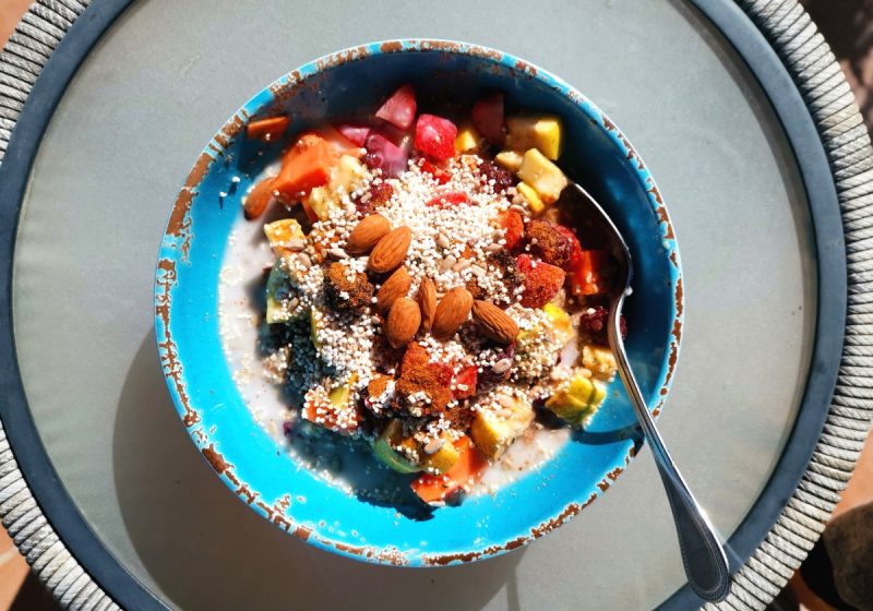 A bowl of healthy oats with nuts on a table - a good way on how to eat healthy and cheap while traveling