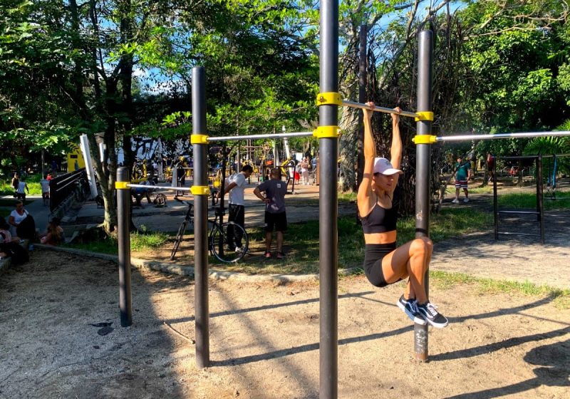 Katharina hanging from a bar in a free workout park - one of our favorite ways to stay fit while traveling!