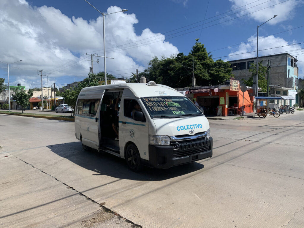 Colectivo driving down the road in Playa Del Carmen