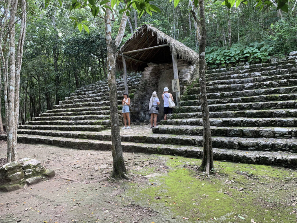 Looking at a carved stelae at the Macanxoc Group in Coba