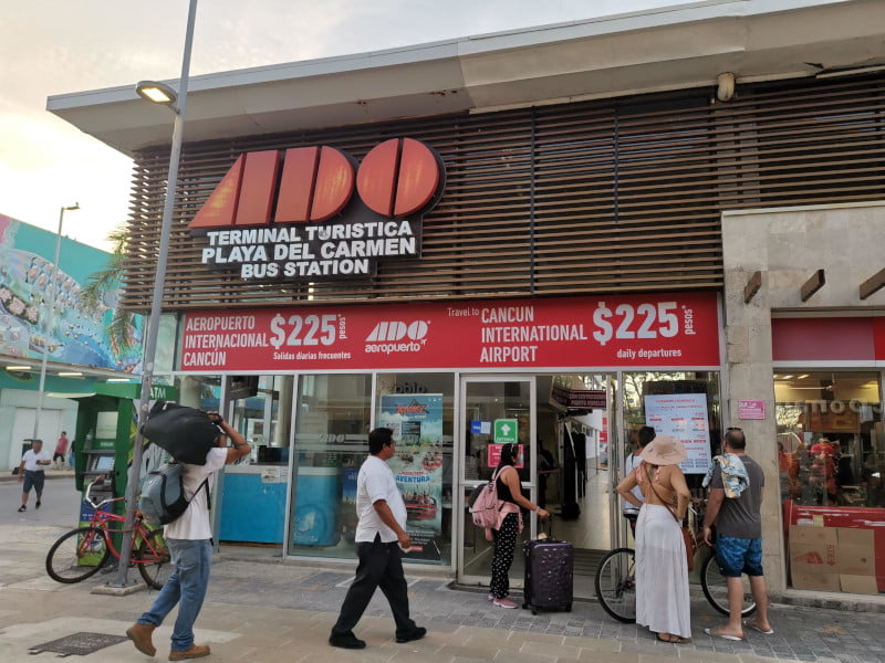 People standing in front of the entrance of the ADO terminal turistica Playa del Carmen  bus station 