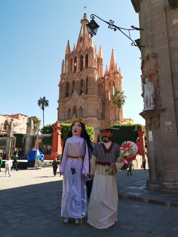 Mojiangas standing in front of the Cathedral only in Christmas costumes for Christmas in San Miguel de Allende