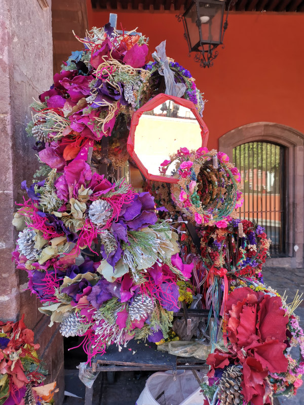 Christmas flower wreaths in dark red, purple and pink for sale on the street for Christmas in San miguel