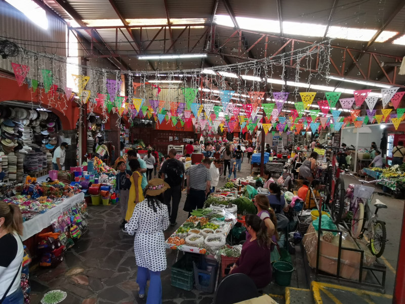 Inside of the Ignacio Ramirez market with colorful flags hanging from the ceiling
