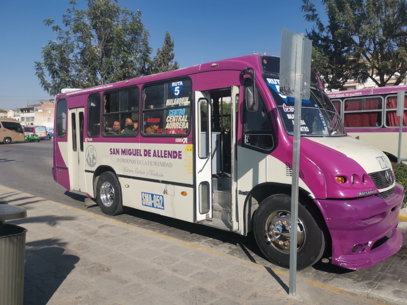 A city bus waiting at a bus stop, a cheap way to get around San Miguel de Allende