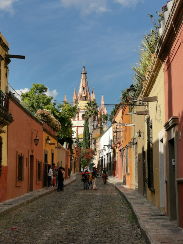 View down a beautiful street in San Miguel De Allende with the roof of the cathedral in the background