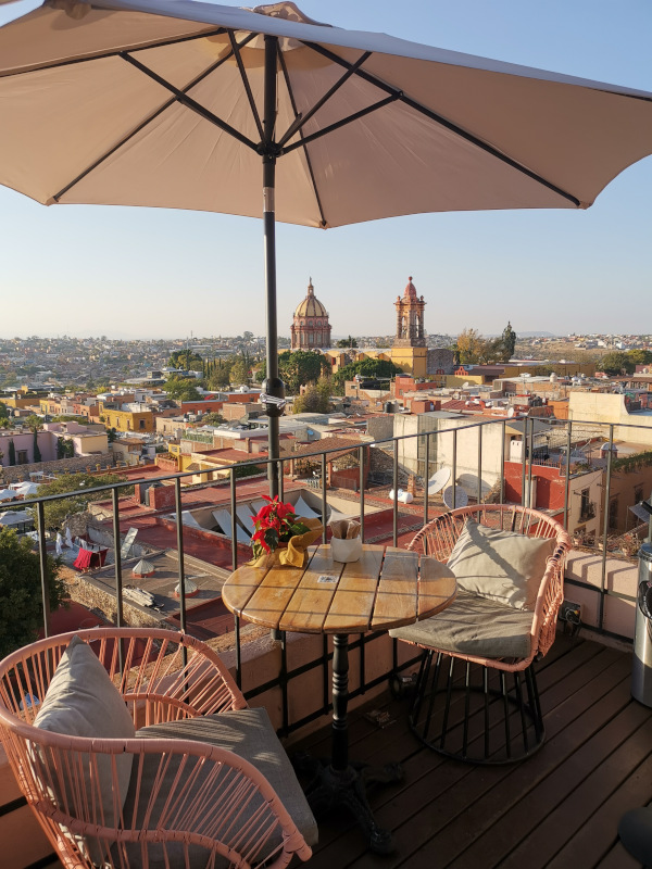 An empty table with two chairs overlooking an amazing view from the rooftop of the Selina hotel in San Miguel de Allende