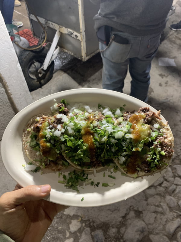 Plate of tacos de cabeza with lots of onions and cilantro from Tacos Santos in San Miguel de Allende