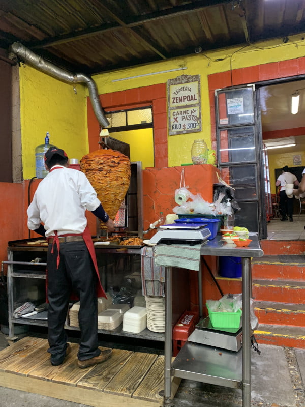 Worker in a restaurant preparing al pastor tacos in San Miguel de Allende