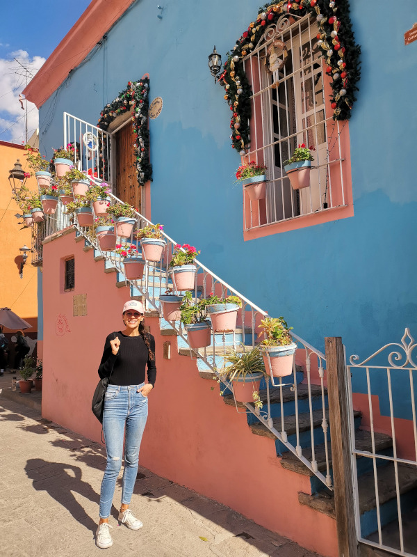 Katharina standing in front of a house that is painted pink and light blue - a gem for Instagrammers in Guanajuato