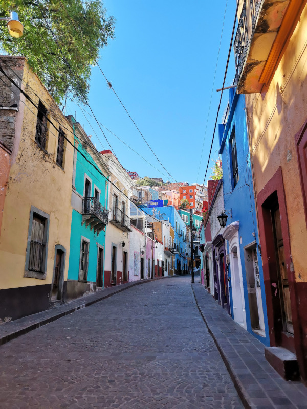 An empty street surrounded by colorful houses - one of the top things to do in Guanajuato