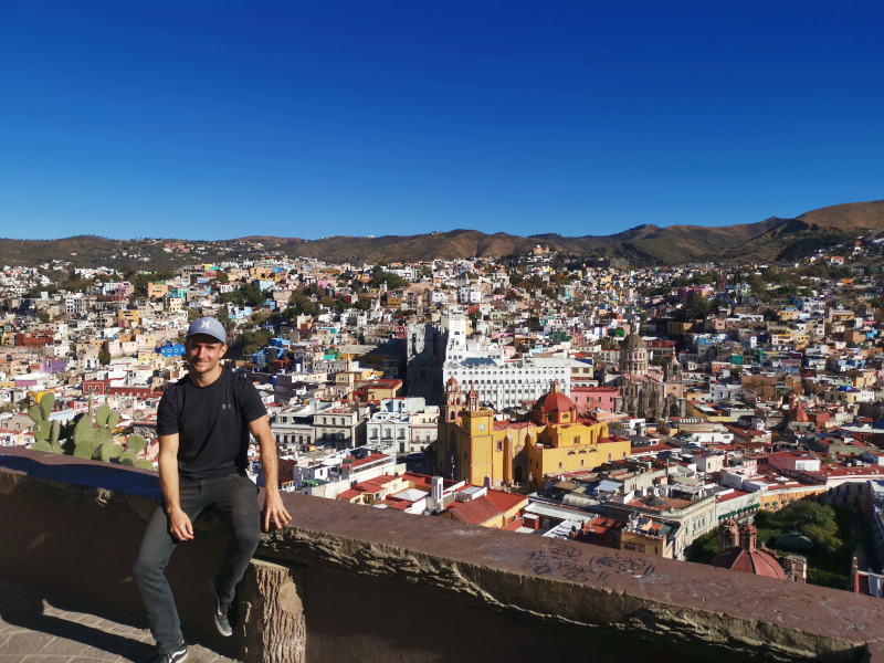 Allan sitting on a ledge from the Monumento Al Pipillia - one of the top things to do in Guanajuato