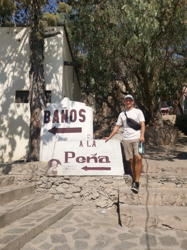 Allan standing next to a sign pointing to the start of the Peña de Bernal hike
