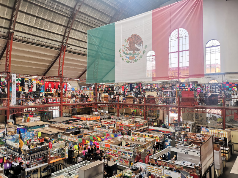A huge Mexican flag hanging over stalls in Guanajuato, Mexico