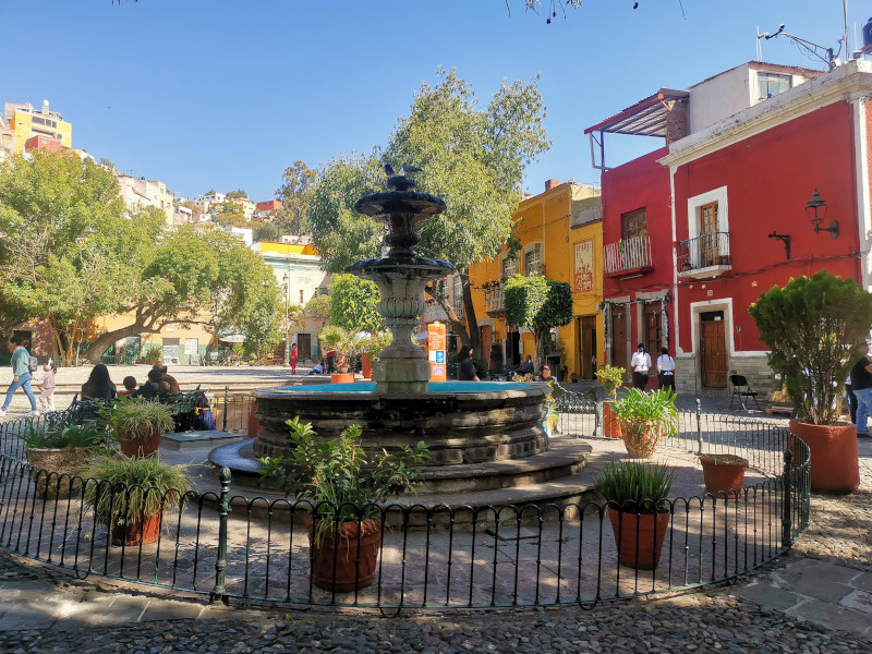 A fountain in the middle of Plaza San Fernando surrounded by colorful buildings in Guanajuato