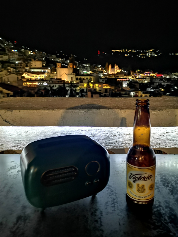 A radio on a table with a beer next to at Bar La Casa de los Radios