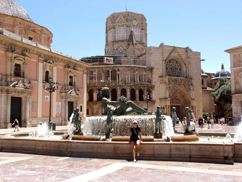 Katharina sitting on the edge of the fountain at the Plaza De La Virgin a great free thing to do in Valencia in one day