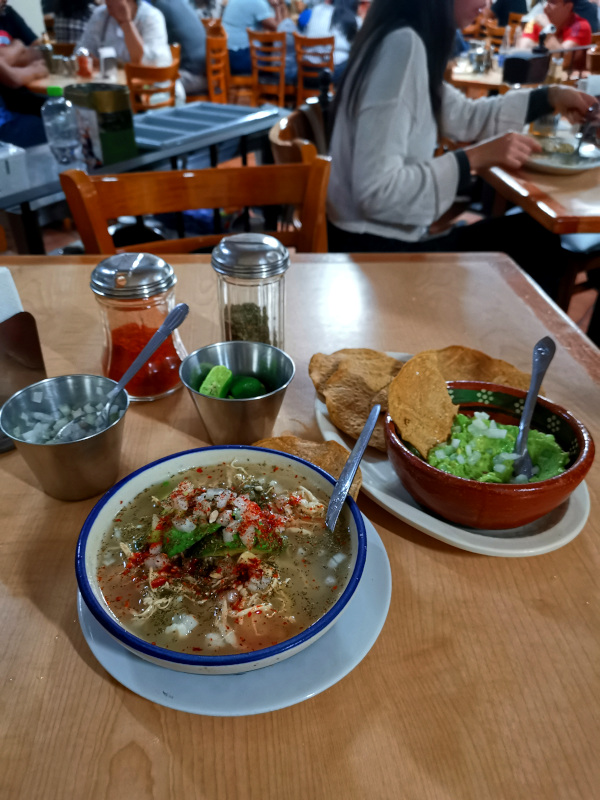 A bowl of Pozole with a bowl of Guacamole on the side - one of the tastiest things to do in Taxco