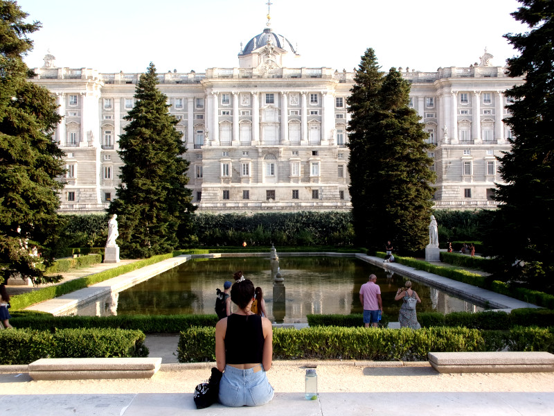 Katharina sitting in front of a pond by the rRyal palace in Madrid a great free thing to do in Madrid