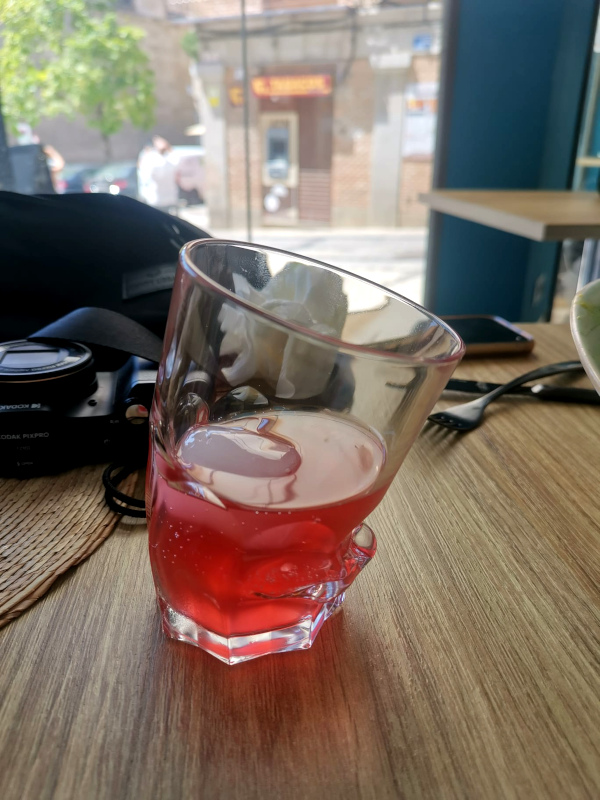 Pink juice in a glass that is shaped as a face