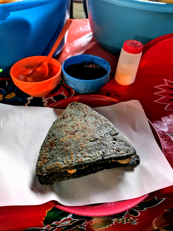 Itacate - a blue triangle shaped gorditae on a plate at Tepoztlán market 