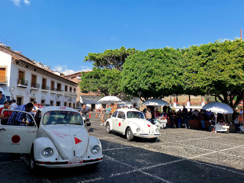 Two VW's driving around the Zocolo in Taxco, one of the best things to do in Taxco