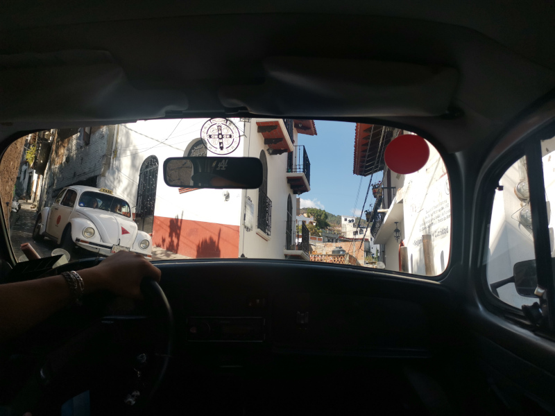 The view out of a VW beetle windscreen as it drives up a steep street