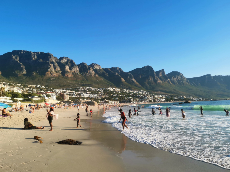 People enjoying a swim at Camps Bay one of the best fun activities in Cape Town