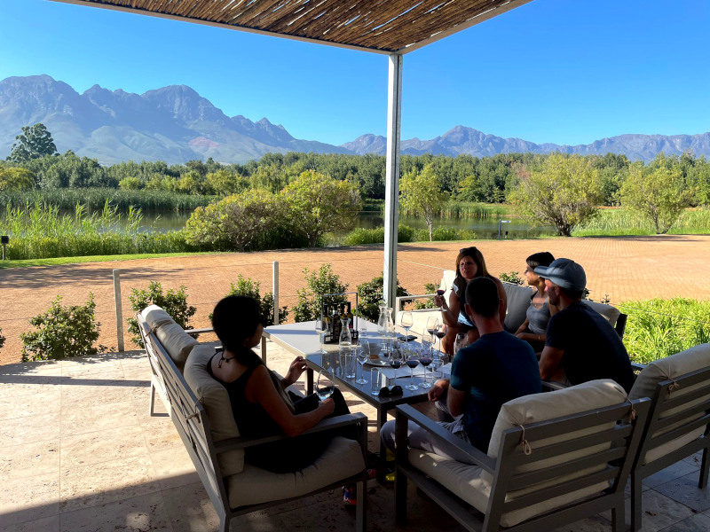 Group of people sitting at a table at a wine farm in Cape Town