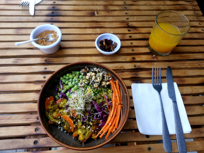 Healthy vegan food in a colorful bowl on a wooden table at a vegan restaurant in Mexico City