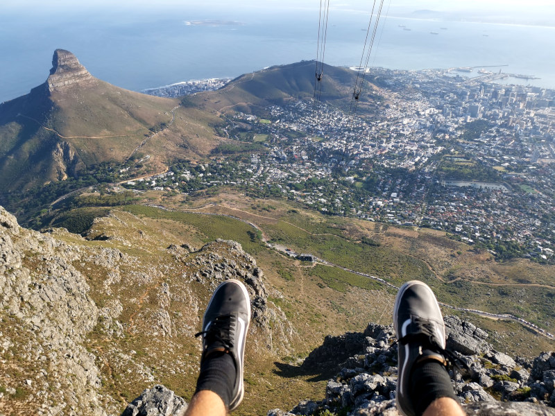 Feet hanging over the edge of a cliff on the India Venster hike in Cape Town
