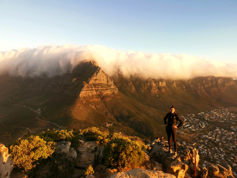 Katharina standing on the top of Lion's Head at sunset one of the best hikes around Cape Town
