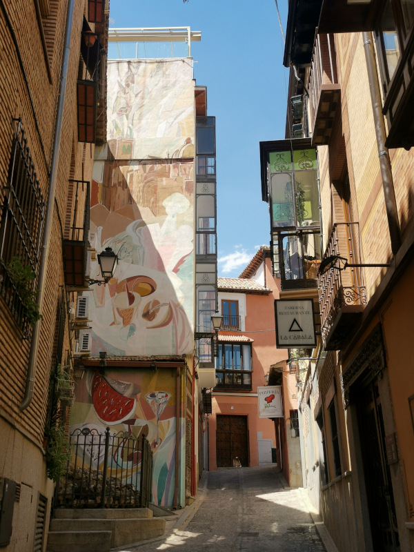 A colorful street in Toledo, Spain with streetart and signs