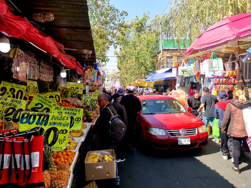 Car driving through the middle of a busy outdoor market in Mexico City