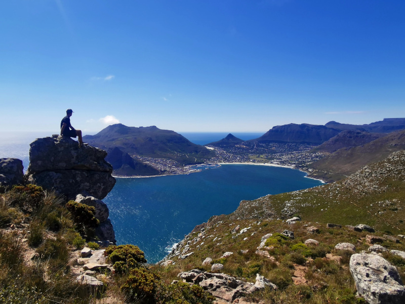 Sitting on a rock overlooking Hout Bay in Cape Town