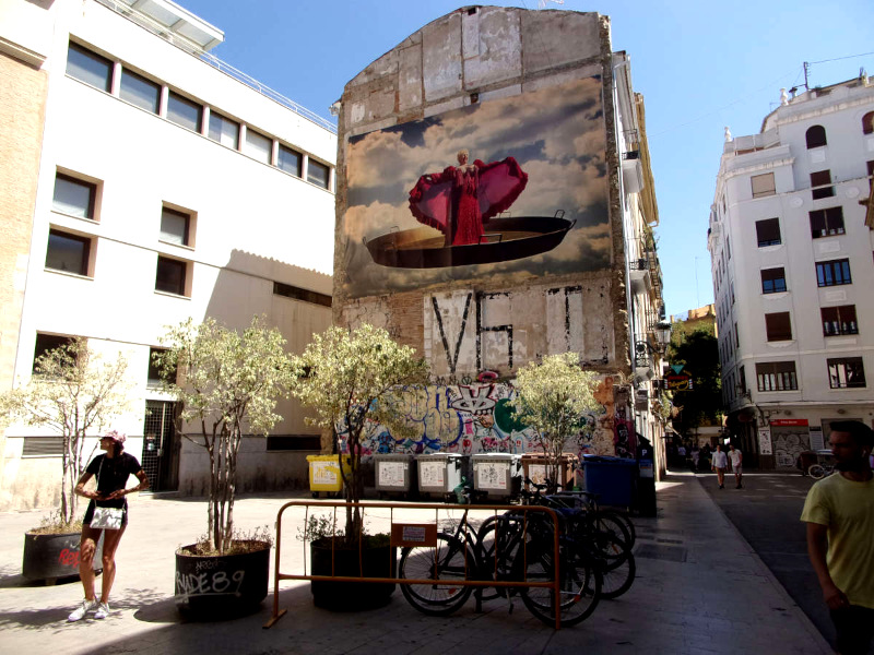 Street art showing a woman in a pink gown singing on a wall in Valencia