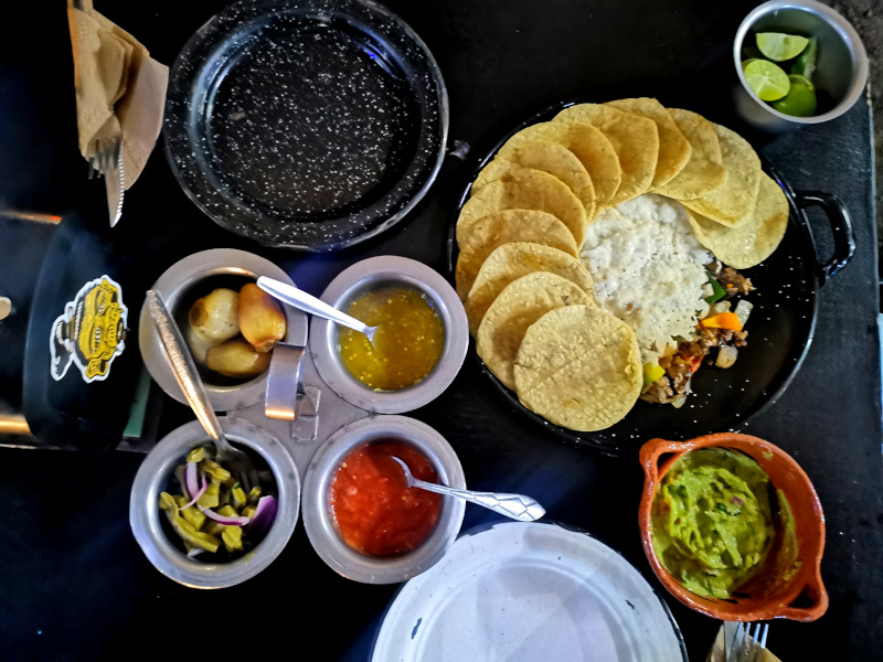 A table full of vegan food, tortillas, guacamole and sauces from Por Siempte Vegana taqueria in Mexico City