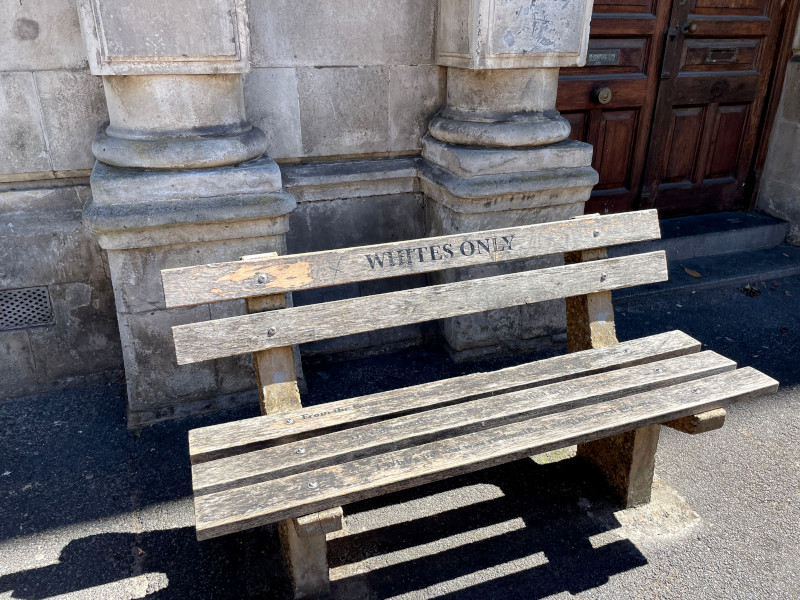 A wooden bench with whites only written on it seen on a walking tour which is a fun activity in Cape Town