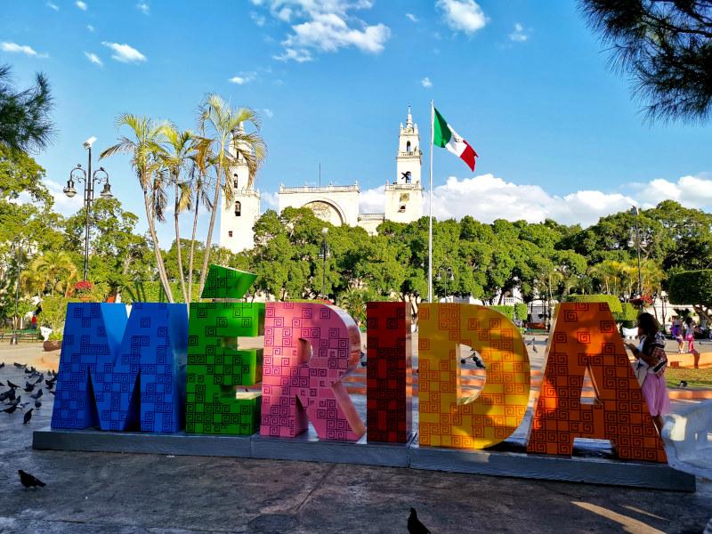 Colorful letters in a town square with a church in the background in the town of Merida one of the best cities in Mexico for digital nomads