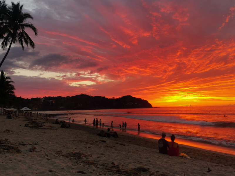 People siiting on the beach enjoying sunset in Sayulita one of the best cities in Mexico for digital nomads