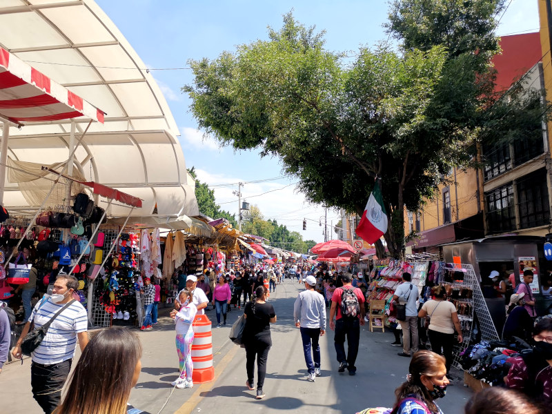 A street with people and stalls sending clothing in Tepito market