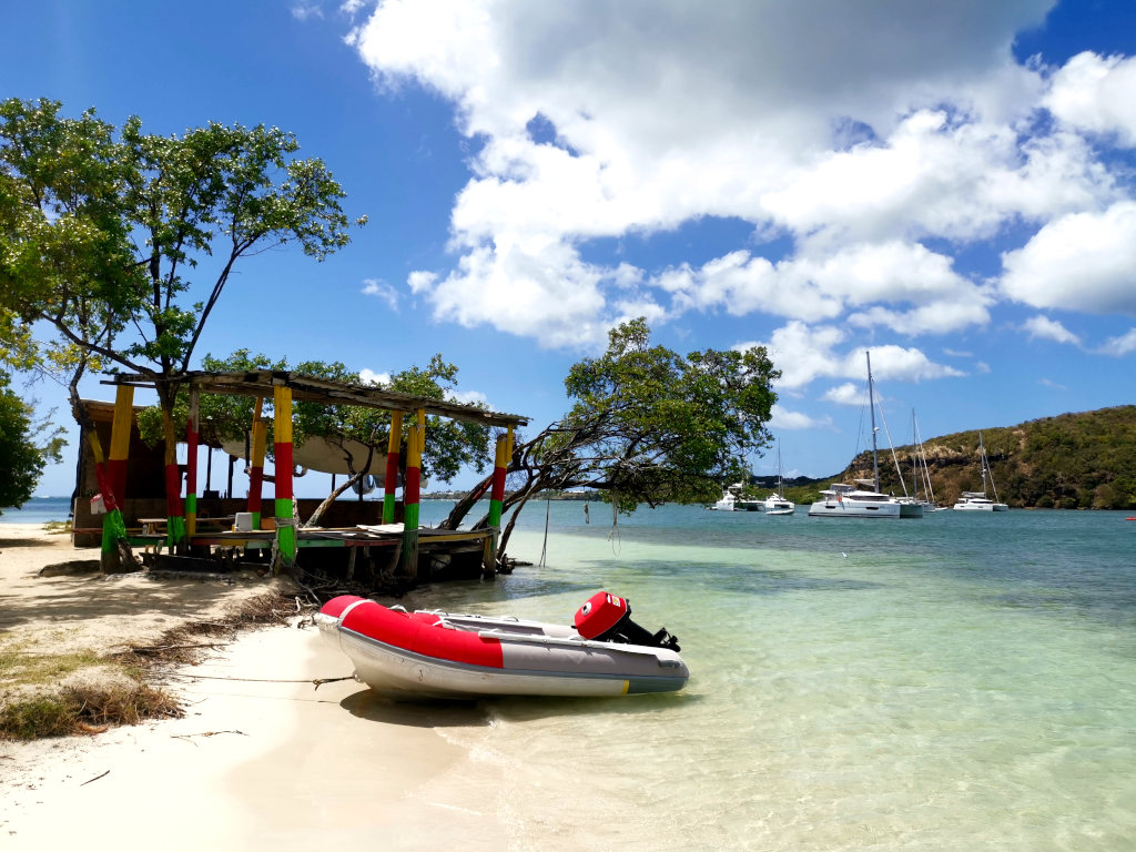 A small inflatable boat tied to the shore at Hog Island in Grenada
