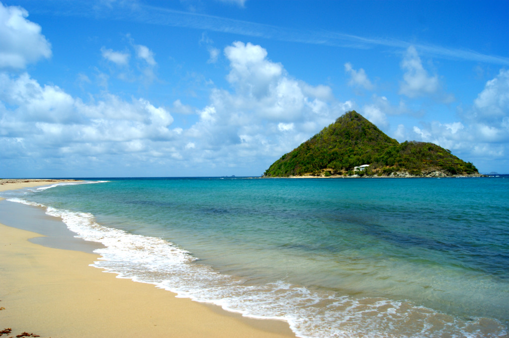 The white sandy beach of Levera Beach with the conical sugar loaf island off its shores