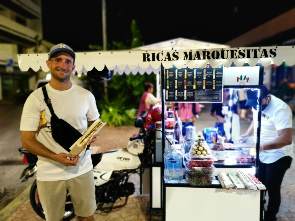 A man holding a marquesita in his hands a cheap eats in Playa del Carmen