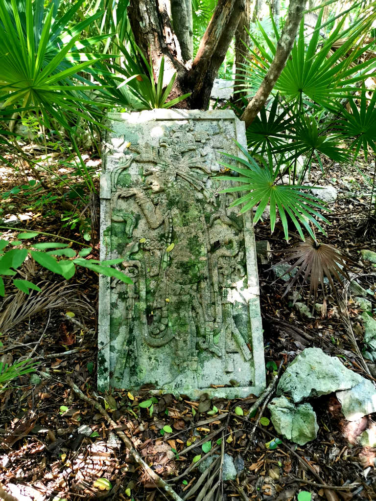 Mayan-style artwork scattered in the jungle around Cenote Azul