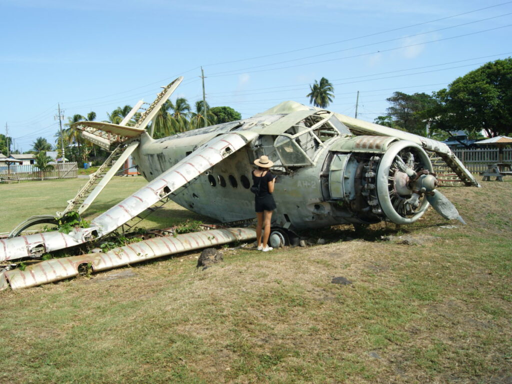 A woman looking inside an abandoned plane at pearls aiport in grenada