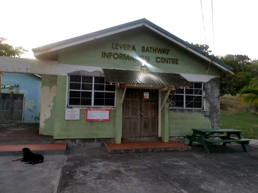 The Levera Bathway information centre and old rundown building in Grenada with a dog sitting on the ground