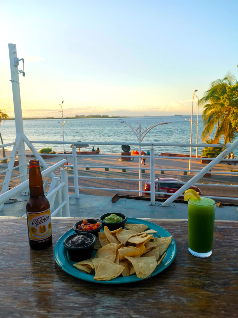 Drinks and chips at Harkers with a view of the malecon la paz in the background
